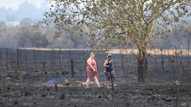 Residents stroll through the ash after a bushfire at Bundamba. Picture: Rob Williams