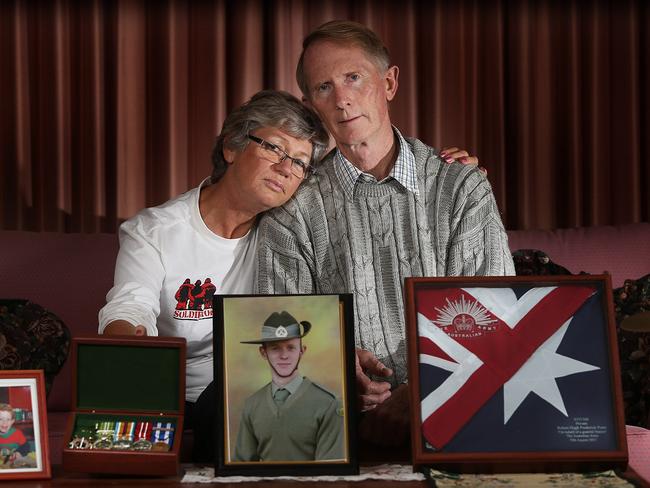 Janny and Hugh Poate at home in Canberra with a portrait of their dead son Robbie. Private Robert "Robbie" Poate of the 6th Battalion Royal Australian Regiment was murdered by a rogue Afghan National Army soldier on the 29th August 2012 at a small patrol base in Uruzgan province in southern Afghanistan. He was one of three diggers cut down by the lone gunman after a game of cards on the evening of the 29th August. His mum and dad, Hugh and Janny Poate who live in Canberra, are coming to terms with their son's death but admit it is a struggle. They will travel to Brisbane to spend ANZAC Day with their son's mates, at the 6th Battlion Diggers club.