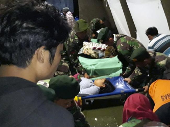 Indonesian soldiers tend to the injured. Picture: AP