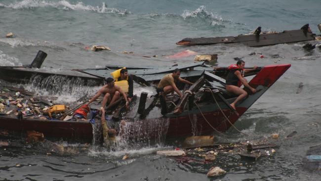 Navy personnel pull survivors and dead bodies from the water in 2010.