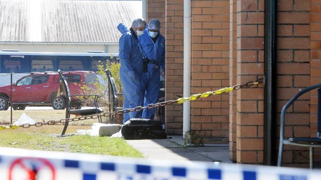 Scenes of Crime Officers outside the unit where Tyrone Michael Baynton, 29, was killed with a samurai sword. Photo Daily Mercury Archives