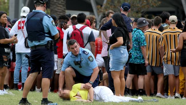 A young woman is held in the recovery position by a police officer before being taken away. Picture: Damian Shaw