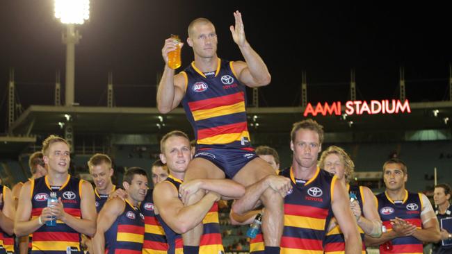 Scott Thompson gets chaired off the ground by Brent Reilly and Ben Rutten after his 200th game.