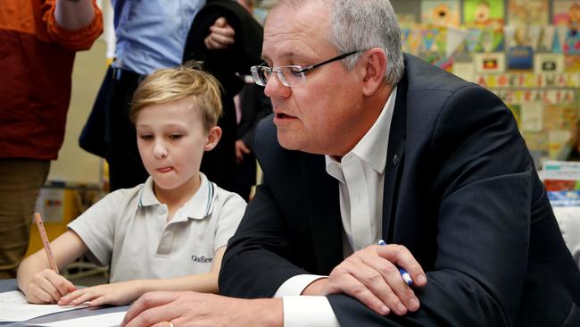 Mr Morrison checks in on school work with Year 1 student Reggie during the Friday school visit. Picture: Jonathan Ng