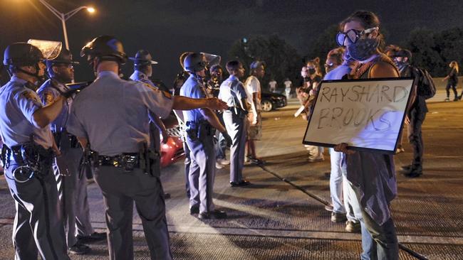 Demonstrators face police officers after getting onto I75 and shutting down the interstate in Atlanta. Picture: AP