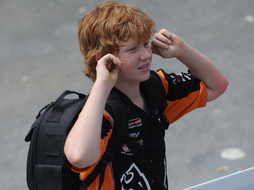 Motor car racing - Clipsal 500. Child spectator watching the FA-18 Hornet fly past with fingers in his ears.