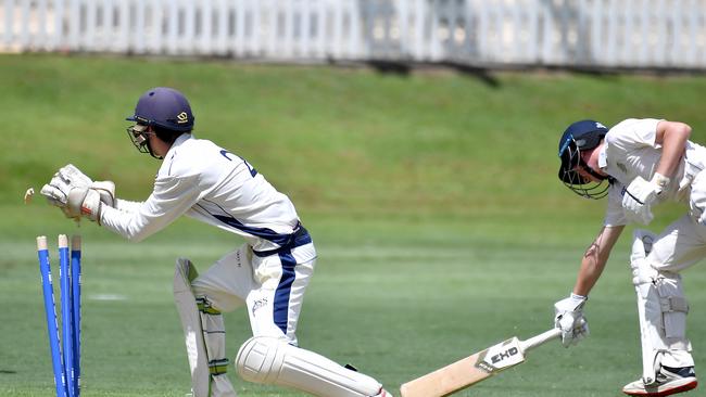 Nudgee batsman Kane Neilson gets home for a run despite Daniel Statham’s glove work. Picture, John Gass