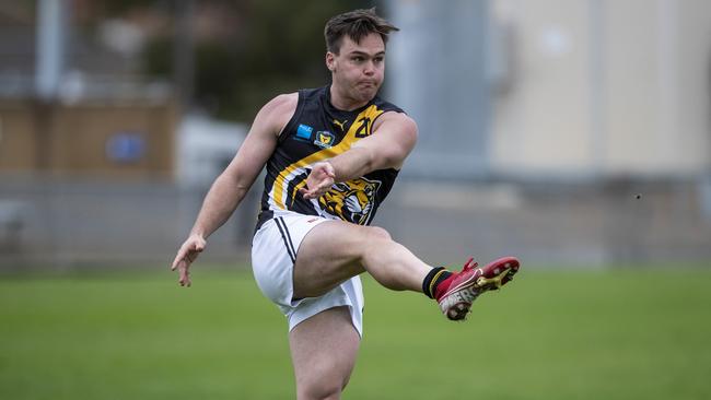 Tigers' Kieran Lovell kicks the ball into his team's forward 50. Picture: Luke Bowden