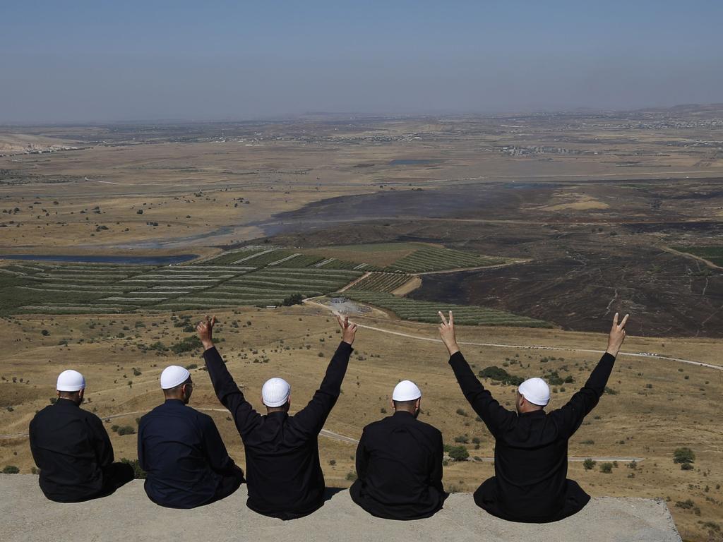 Men of the Druze faith at the Israeli-annexed Golan Heights flash the V for victory sign as they look out across southwestern Syria. Picture: AFP