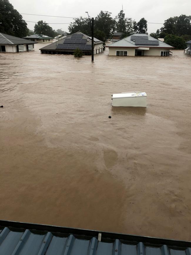 A fridge floats down a Lismore street at the height of the crisis.