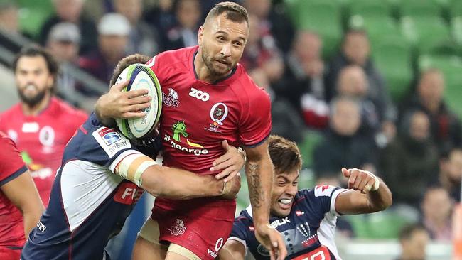 Quade Cooper is tackled by Rebels defenders.