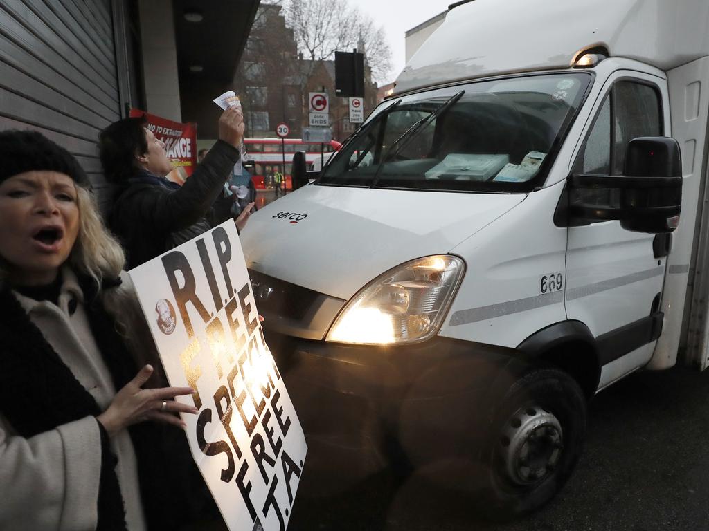 Supporters of WikiLeaks founder Julian Assange protest in front of a prison van entering Westminster Magistrates Court in London. Picture: AP Photo/Frank Augstein