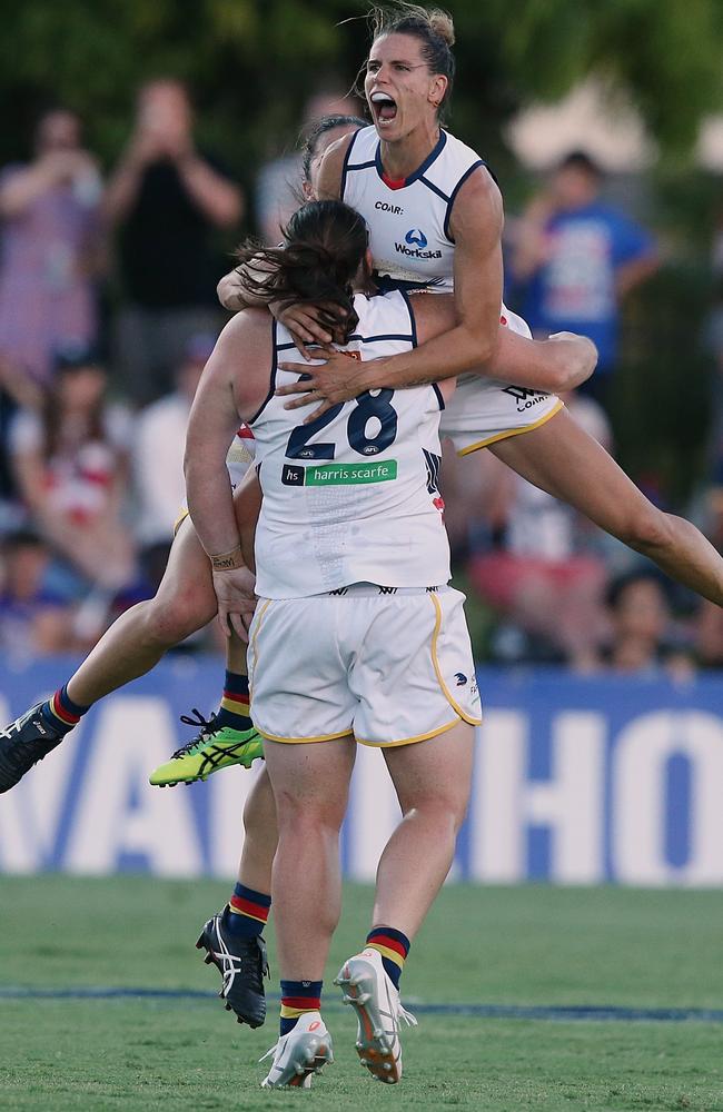 Chelsea Randall jumps on Sarah Perkins after Perkins kicked a goal.