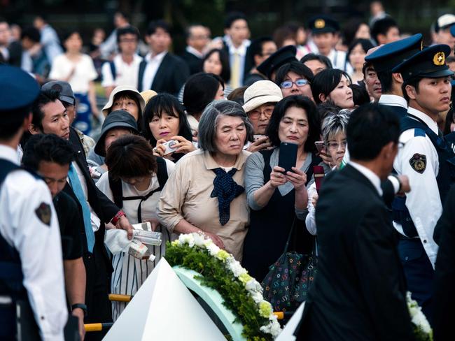 People try to get a glimpse of the wreath laid by US President Obama at the Hiroshima Peace Memorial park cenotaph in Hiroshima.