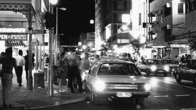 A police officer talking to youths, around 11.30pm in the early 1990s.