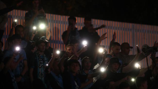 Sydney FC fans turn on their phones for light after the match was abandoned for safety reasons due to lightning. Picture: Mark Metcalfe/Getty Images