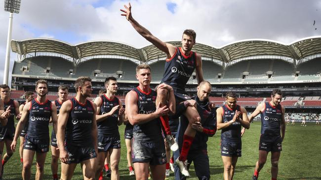 Michael Talia and Jace Bode chair Brady Dawe off Adelaide Oval after his final game for the club. Picture: Sarah Reed