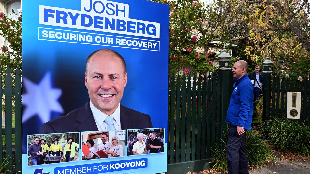 Australia's treasurer Josh Frydenberg looks at a campaign billboard in Melbourne. (Photo by William WEST / AFP)