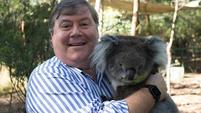 Professor Chris Daniels, chief executive officer of the International Koala Centre of Excellence, cuddling a koala at Cleland Wildlife Park.