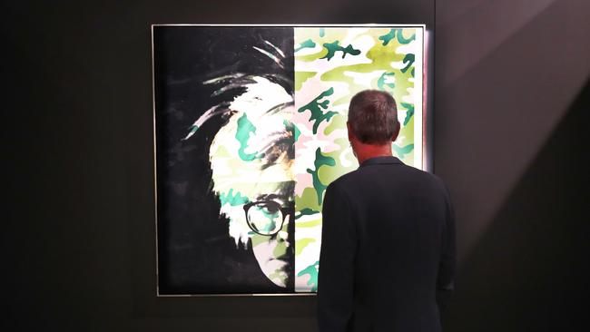 Bradley Vincent with Andy Warhol self-portrait (Camouflage) at HOTA. Picture Glenn Hampson