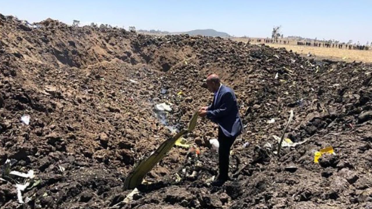 A man inspecting what is believed to be wreckage at the crash site of an Ethiopia Airlines aircraft near Bishoftu, a town some 60km southeast of Addis Ababa, Ethiopia.