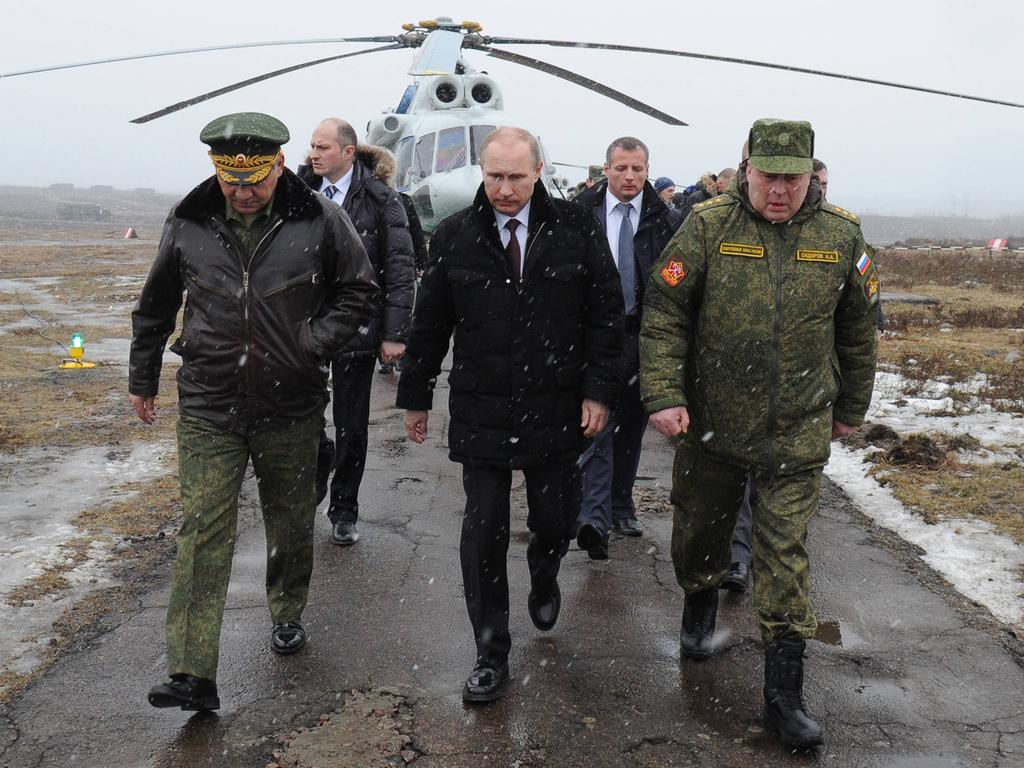 Russia's President Vladimir Putin (front C) and Defence Minister Sergei Shoigu (front L)  walk to watch military exercises upon his arrival at the Kirillovsky firing ground in the Leningrad region, on March 3, 2014. Crimea, the strategic host to tsarist and Kremlin navies since the 18th century, has been under de facto occupation by Moscow-backed forces since Putin won recently parliament's authorisation to send troops into Ukraine. AFP PHOTO/ RIA-NOVOSTI/ POOL/ MIKHAIL KLIMENTYEV (Photo by MIKHAIL KLIMENTYEV / RIA-NOVOSTI / AFP)