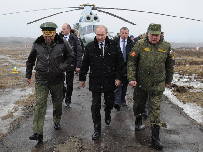 Russia's President Vladimir Putin (front C) and Defence Minister Sergei Shoigu (front L)  walk to watch military exercises upon his arrival at the Kirillovsky firing ground in the Leningrad region, on March 3, 2014. Crimea, the strategic host to tsarist and Kremlin navies since the 18th century, has been under de facto occupation by Moscow-backed forces since Putin won recently parliament's authorisation to send troops into Ukraine. AFP PHOTO/ RIA-NOVOSTI/ POOL/ MIKHAIL KLIMENTYEV (Photo by MIKHAIL KLIMENTYEV / RIA-NOVOSTI / AFP)