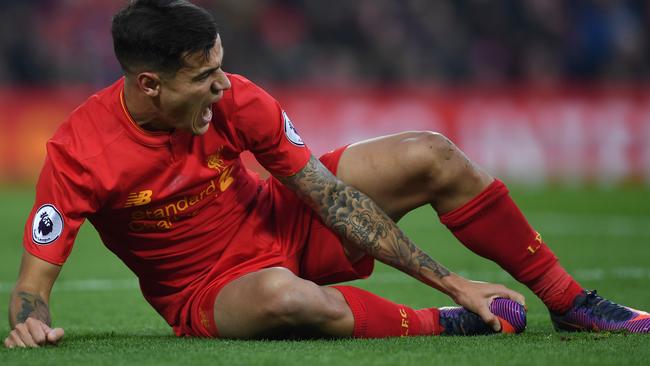 Liverpool's Brazilian midfielder Philippe Coutinho holds his foot after picking up an injury against Sunderland.