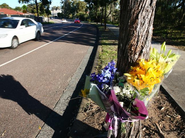 Floral tributes at Lake Haven Drive, where Jayden Mason was found unconscious on the road and later died. Picture: Peter Clark