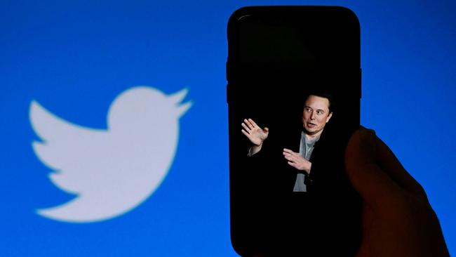 A phone screen in October 2022 displays a photo of Elon Musk in Washington DC with the Twitter logo in the background. Picture: Olivier Douliery/AFP