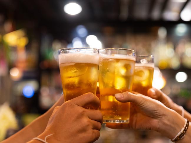 Group of happy friends drinking and toasting beer at brewery bar restaurant - Friendship concept with young people having fun together at cool vintage pub - Focus on middle pint glass