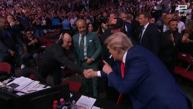 Former president Donald Trump shakes hands with Joe Rogan.