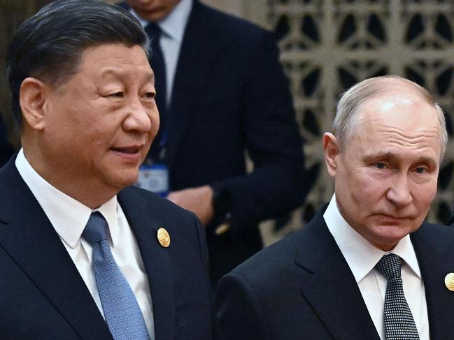 This pool photograph distributed by Russian state owned agency Sputnik shows Russia's President Vladimir Putin (R) and China's President Xi Jinping heading to a group photo session during the third Belt and Road Forum for International Cooperation at the Great Hall of the People in Beijing on October 18, 2023. (Photo by Grigory SYSOYEV / POOL / AFP)