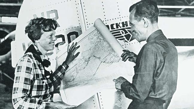 Earhart and her navigator, Fred Noonan, with a map of the Pacific that shows the planned route of their last flight. Picture: Getty Images