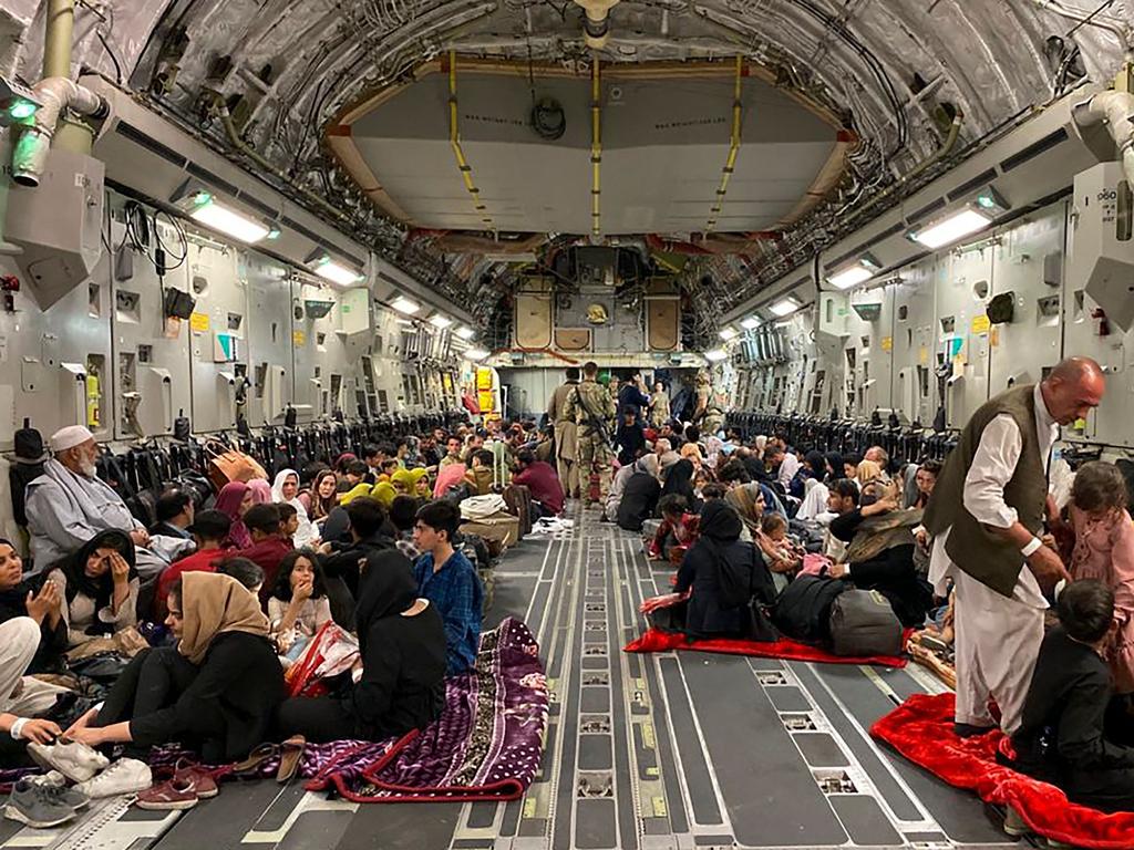 -- AFP PICTURES OF THE YEAR 2021 --  Afghan people sit inside a U S military aircraft to leave Afghanistan, at the military airport in Kabul on August 19, 2021 after Taliban's military takeover of Afghanistan. (Photo by Shakib RAHMANI / AFP) / AFP PICTURES OF THE YEAR 2021