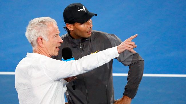 Spain's Rafael Nadal talks to former US tennis player John McEnroe (L) after the men's singles match against Australia's Matthew Ebden on day three of the Australian Open tennis tournament in Melbourne on January 16, 2019. (Photo by DAVID GRAY / AFP) / -- IMAGE RESTRICTED TO EDITORIAL USE - STRICTLY NO COMMERCIAL USE --