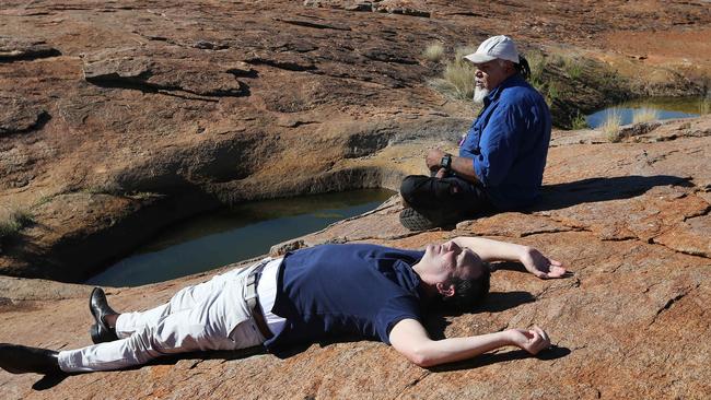 Steven Marshall and APY Cultural Liasion and Aboriginal elder Lee Brady relax in the sun near rock pools in the APY Lands. Picture: Dylan Coker