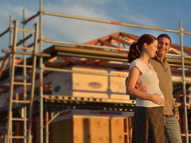 A young couple with their new house under construction