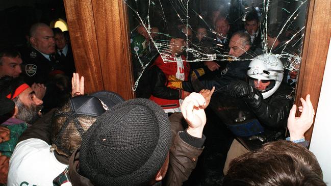 Protesters break through the front door of Parliament House to protest against workplace relations policies.