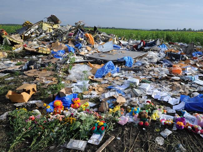 Flowers and plush toys are left at the site of the crash which killed 298 people on-board the doomed flight, including 38 Australians. Picture: AFP