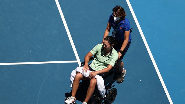 Harmony Tan of France is assisted from Margaret Court Arena after sustaining an injury