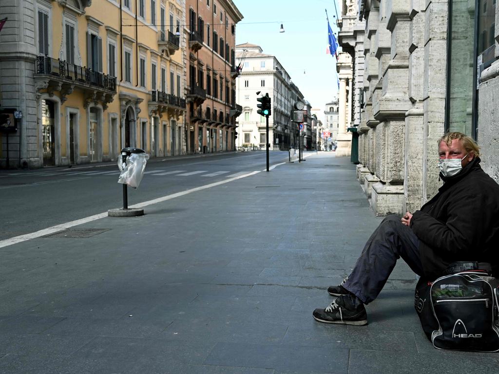 A homeless man sits in a deserted Via del Corso main street in central Rome during lockdown last year. Picture: Vincenzo Pinto/AFP