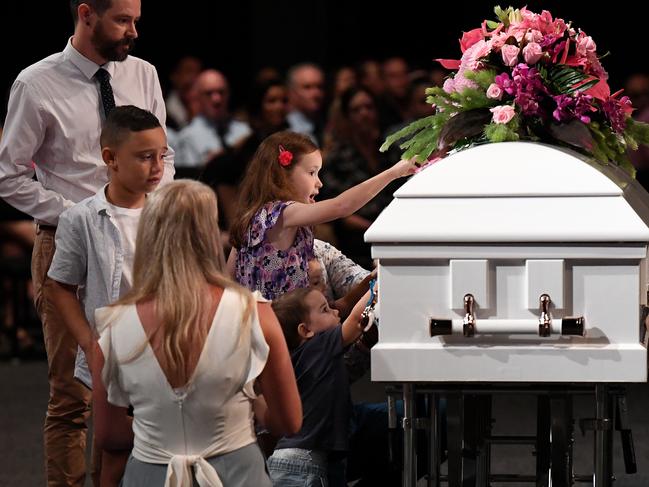 Children place butterfly stickers on the coffin during the funeral for Hannah Clarke and her three children Aaliyah, Laianah and Trey in Brisbane. Picture: Dan Peled/AAP
