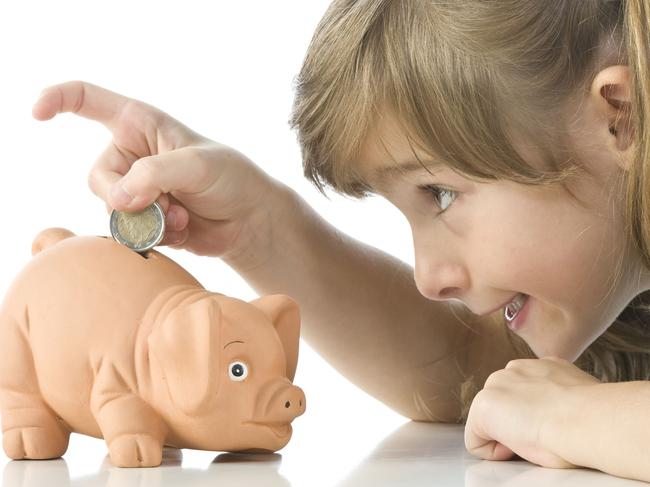 Little girl depositing change in her piggy bank. Child. Children. Money. Kids. Thinkstock. Generic image.