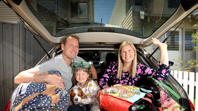 Mark and Andrea Jensen and Alexa, three, load their car up in anticipation of the ring of steel to be lifted. Picture: Andrew Henshaw