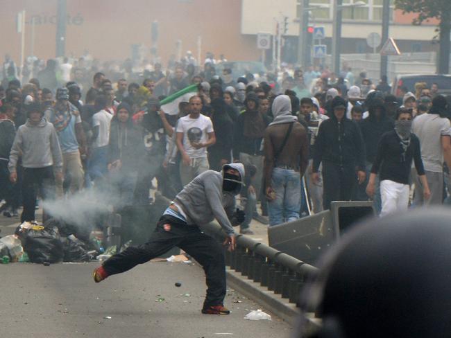 A rioters throws a projectile at French riot police officers in Sarcelles, a suburb north of Paris. AFP PHOTO / PIERRE ANDRIEU