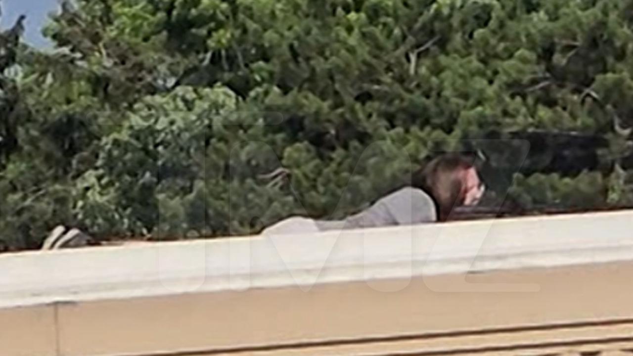 Crooks on the roof of a nearby building, peers through a gun sight. Picture: Backgrid