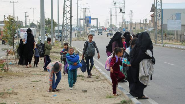 Displaced Palestinians in Rafah in the southern Gaza Strip carry their belongings as they await transportation following an evacuation order by the Israeli army on May 6, 2024. Picture: AFP