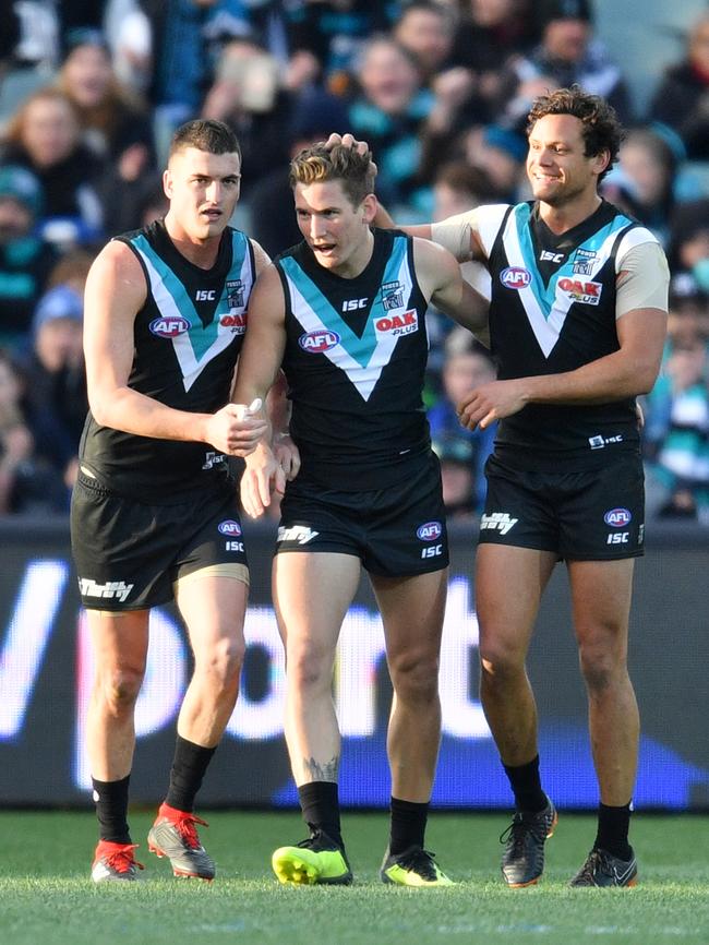 Kane Farrell of the Power celebrates a goal with Tom Rockliff and Steven Motlop against the Eagles. Picture: AAP Image/David Mariuz