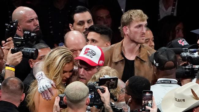 Logan Paul looks on as his brother US YouTuber/boxer Jake Paul hugs his girlfriend Dutch speed skater Jutta Leerdam and his mother Pam Stepnick (hidden) while celebrating winning the heavyweight boxing bout against US retired pro-boxer Mike Tyson.